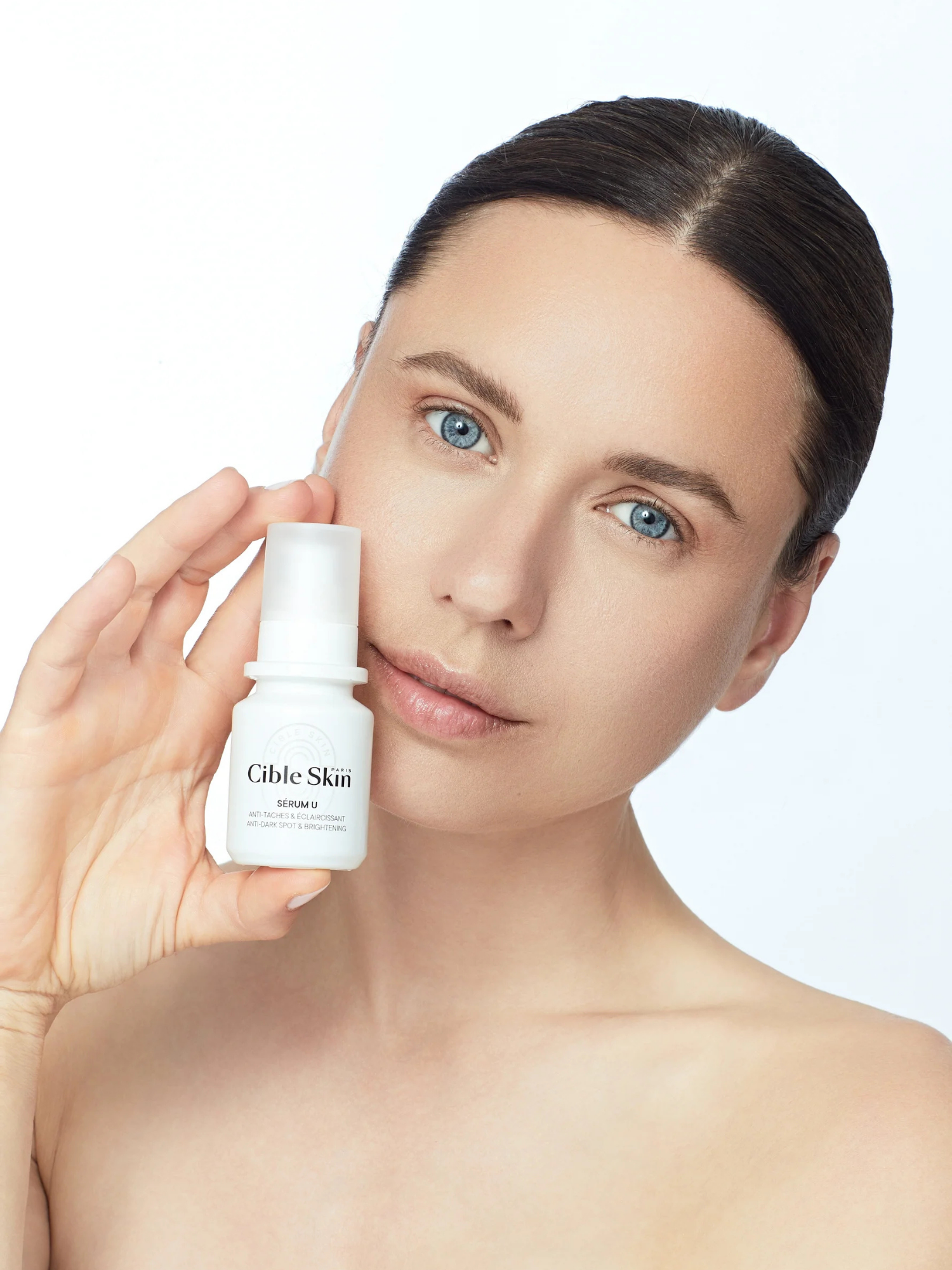 Cible Skin Sérum U dark spot correcting serum 30 mL bottle held by woman